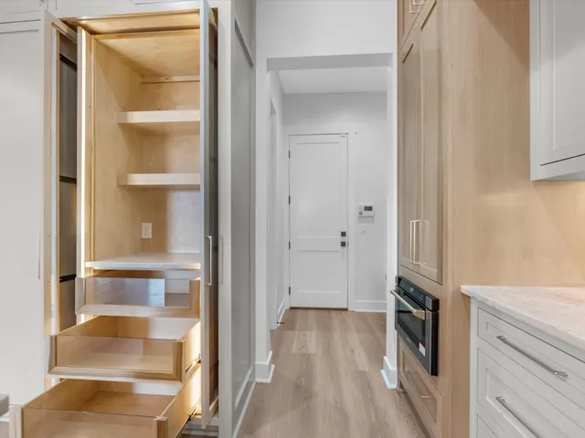 a view of a walk in closet and wooden floor