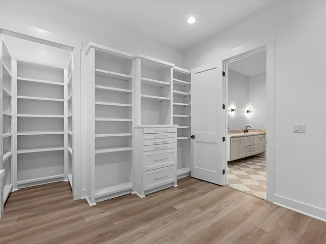 a view of walk in closet with empty racks