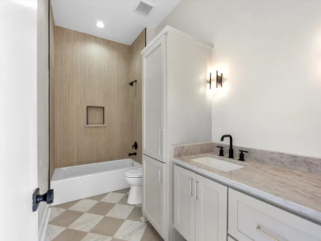 a bathroom with a sink a toilet and shower