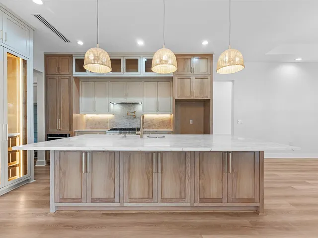 a kitchen with kitchen island stainless steel appliances and wooden floor