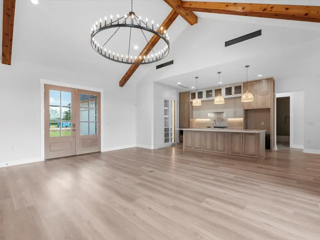 a view of a room with wooden floor and a chandelier