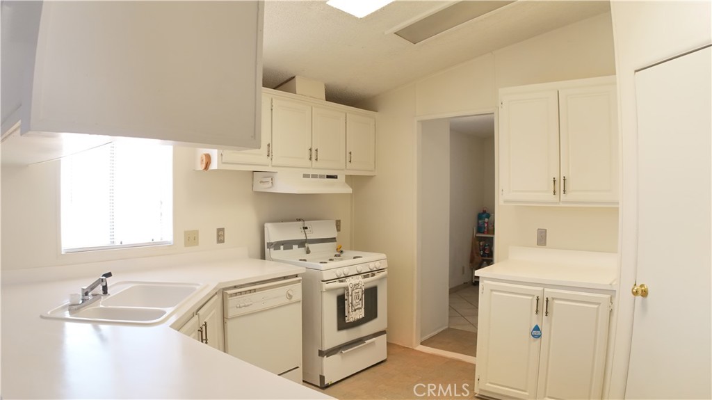 8130 Camp Rock Road Lucerne Valley, CA 92356 - Photo 6 of 14 a view of a kitchen with white cabinets and white appliances