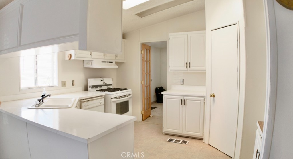 8130 Camp Rock Road Lucerne Valley, CA 92356 - Photo 7 of 14 a kitchen with white cabinets and white appliances