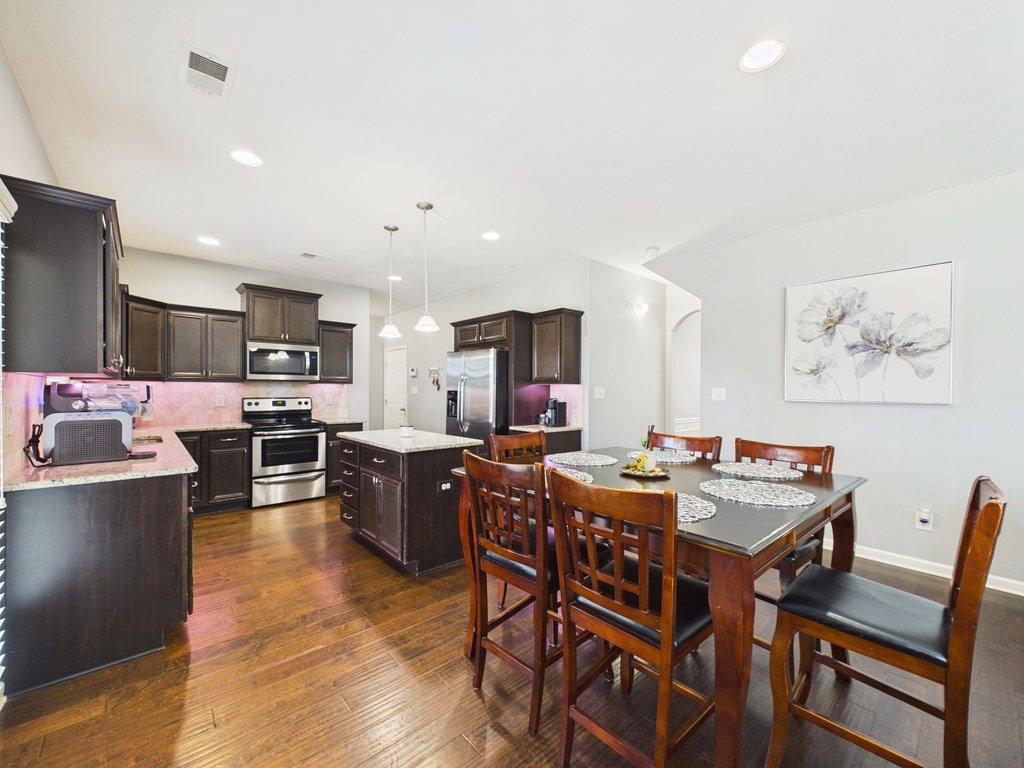 783 Sweetbay Parkway Hamilton, GA 31811 - Photo 12 of 46 a view of a dining room with furniture a kitchen and chandelier