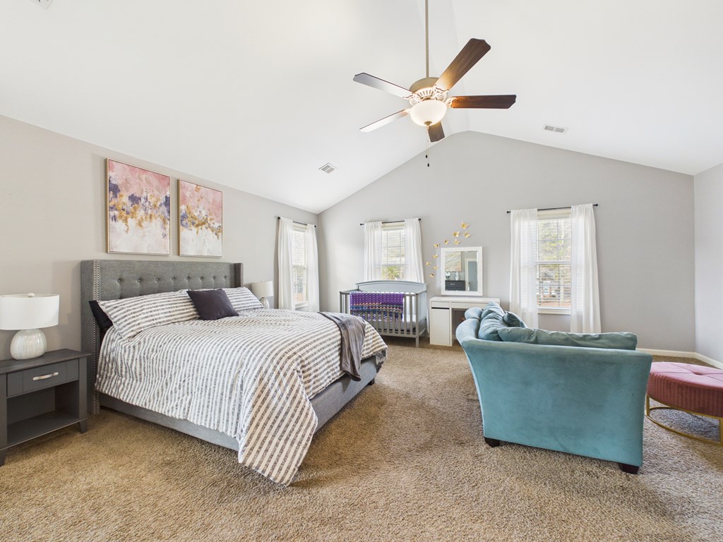 783 Sweetbay Parkway Hamilton, GA 31811 - Photo 19 of 46 a spacious bedroom with a bed a couch and a chandelier