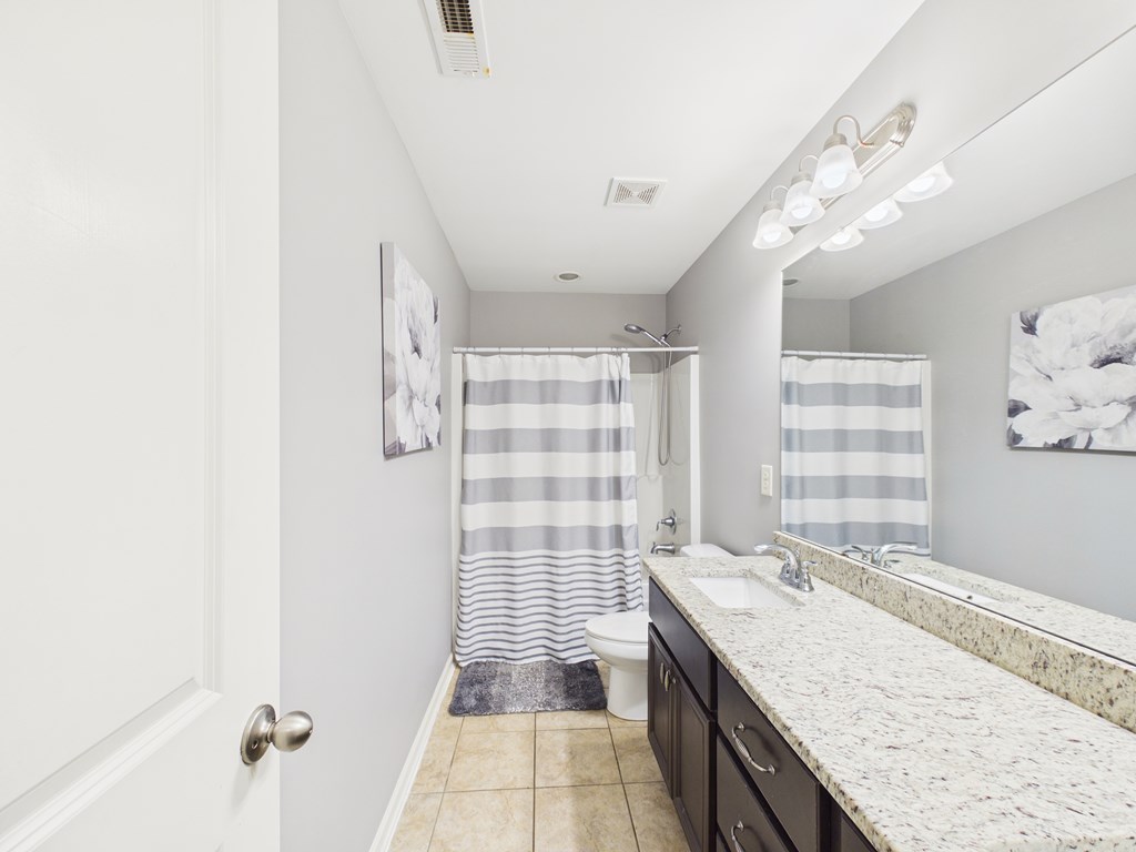783 Sweetbay Parkway Hamilton, GA 31811 - Photo 28 of 46 a bathroom with a granite countertop sink a large mirror and a shower
