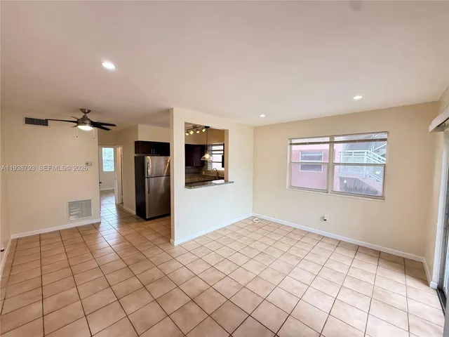 a view of a kitchen with a refrigerator and a stove top oven
