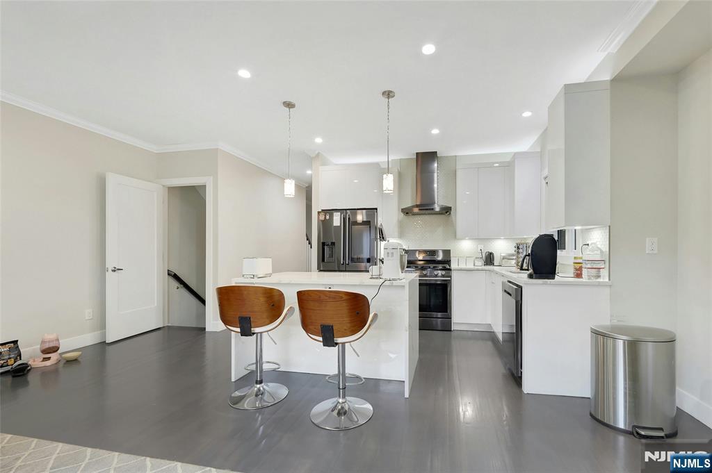 229 6th Street, Unit A Fairview, NJ 07022 - Photo 13 of 35 a kitchen with stainless steel appliances kitchen island granite countertop a stove a sink and a refrigerator with wooden floor