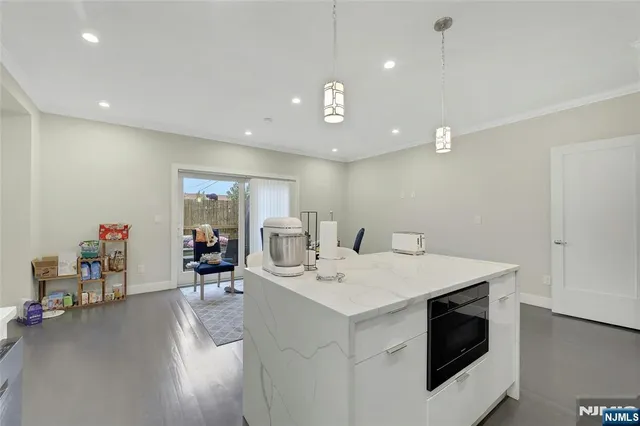 a kitchen with stainless steel appliances kitchen island granite countertop a stove a sink and a refrigerator with wooden floor