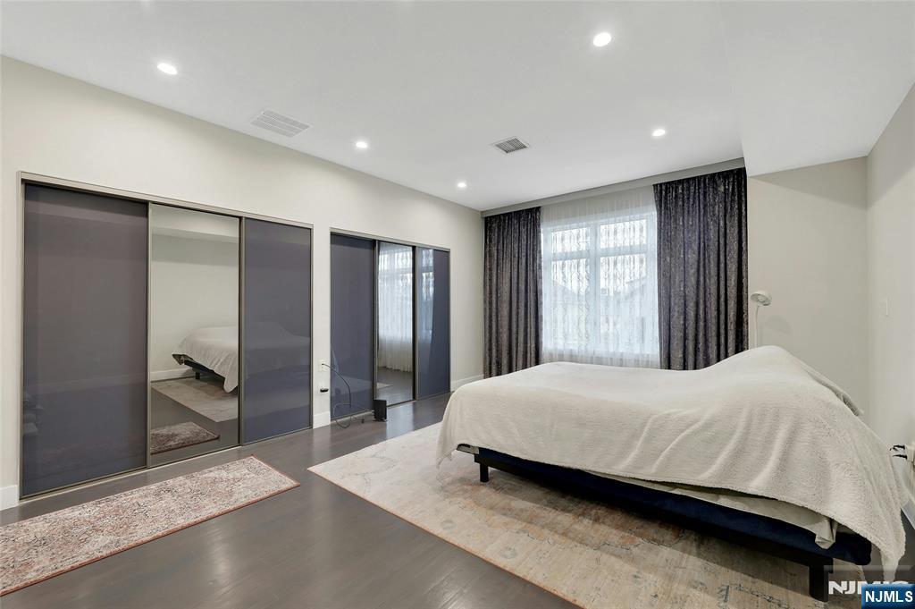 229 6th Street, Unit A Fairview, NJ 07022 - Photo 14 of 35 a room with a bed and a large mirror