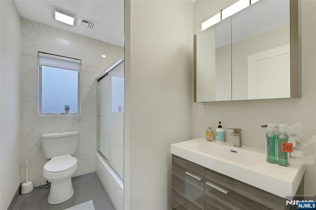 229 6th Street, Unit A Fairview, NJ 07022 - Photo 22 of 35 a bathroom with a sink toilet and vanity