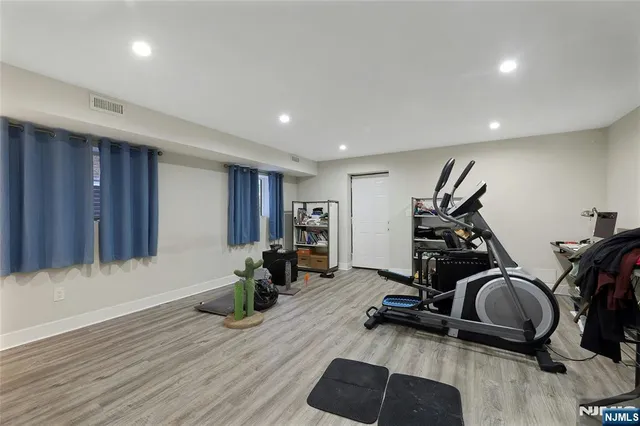 a living room with furniture a flat screen tv and gym equipment