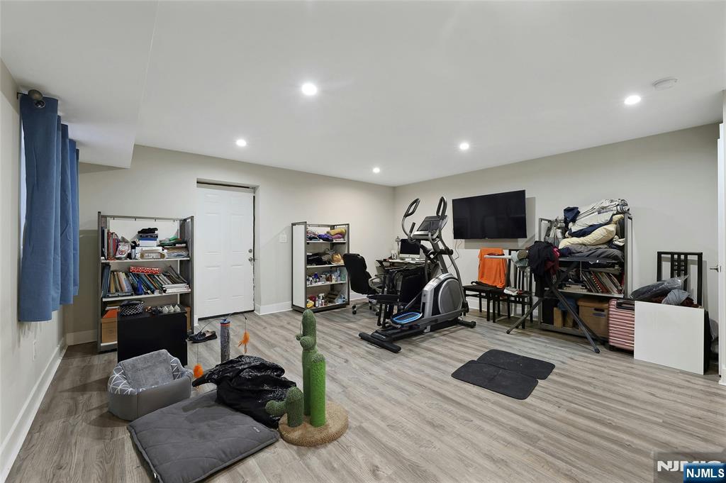 229 6th Street, Unit A Fairview, NJ 07022 - Photo 30 of 35 a living room with furniture a flat screen tv and gym equipment