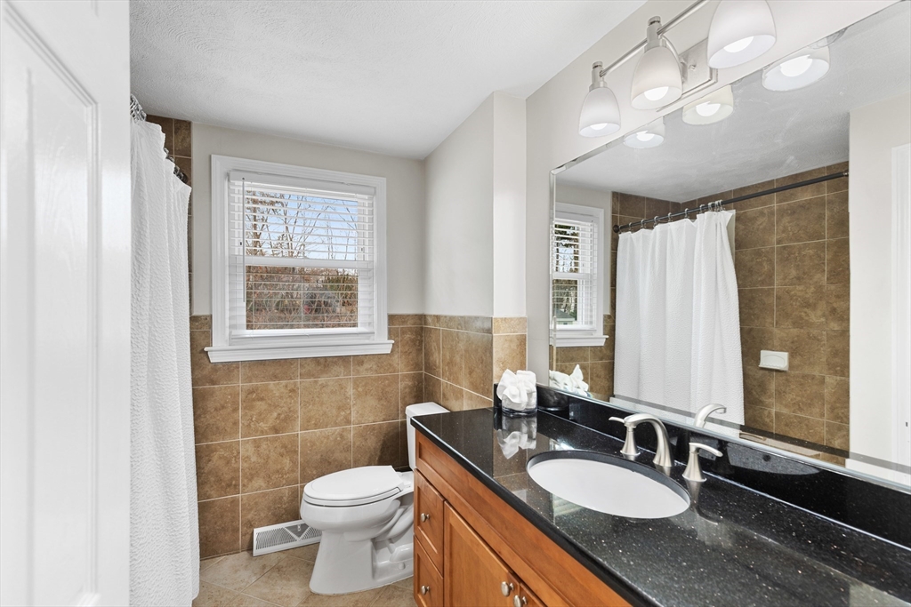 16 Bear Hill Road Billerica, MA 01821 - Photo 14 of 28 a bathroom with a granite countertop double vanity sink a mirror and a toilet