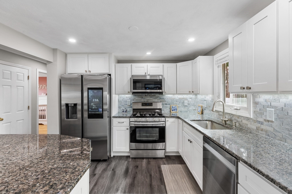 16 Bear Hill Road Billerica, MA 01821 - Photo 5 of 28 a kitchen with granite countertop stainless steel appliances and wooden cabinets