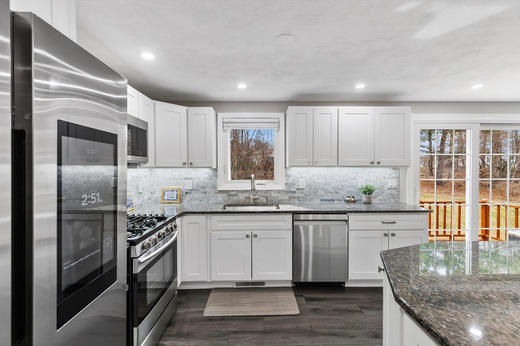 16 Bear Hill Road Billerica, MA 01821 - Photo 6 of 28 a kitchen with granite countertop kitchen island wooden cabinets and stainless steel appliances
