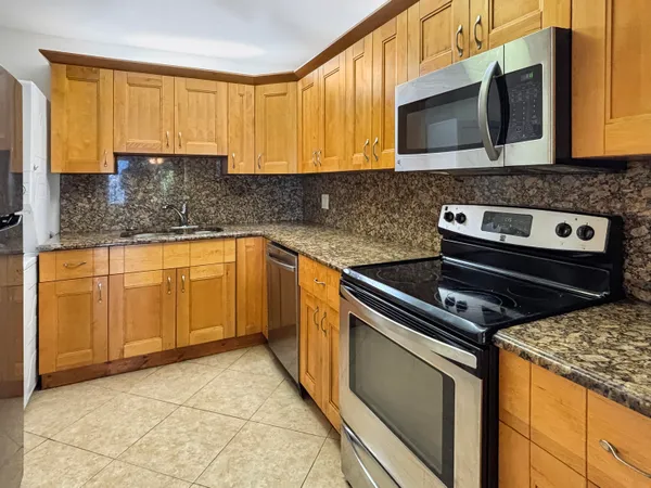 a kitchen with stainless steel appliances granite countertop a stove microwave and sink