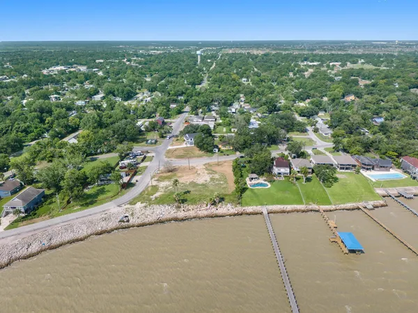an aerial view of a houses with a yard and street