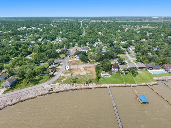 an aerial view of a houses with a yard and street