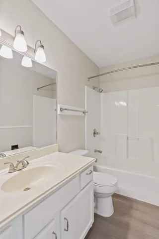 a bathroom with a granite countertop sink a toilet and shower