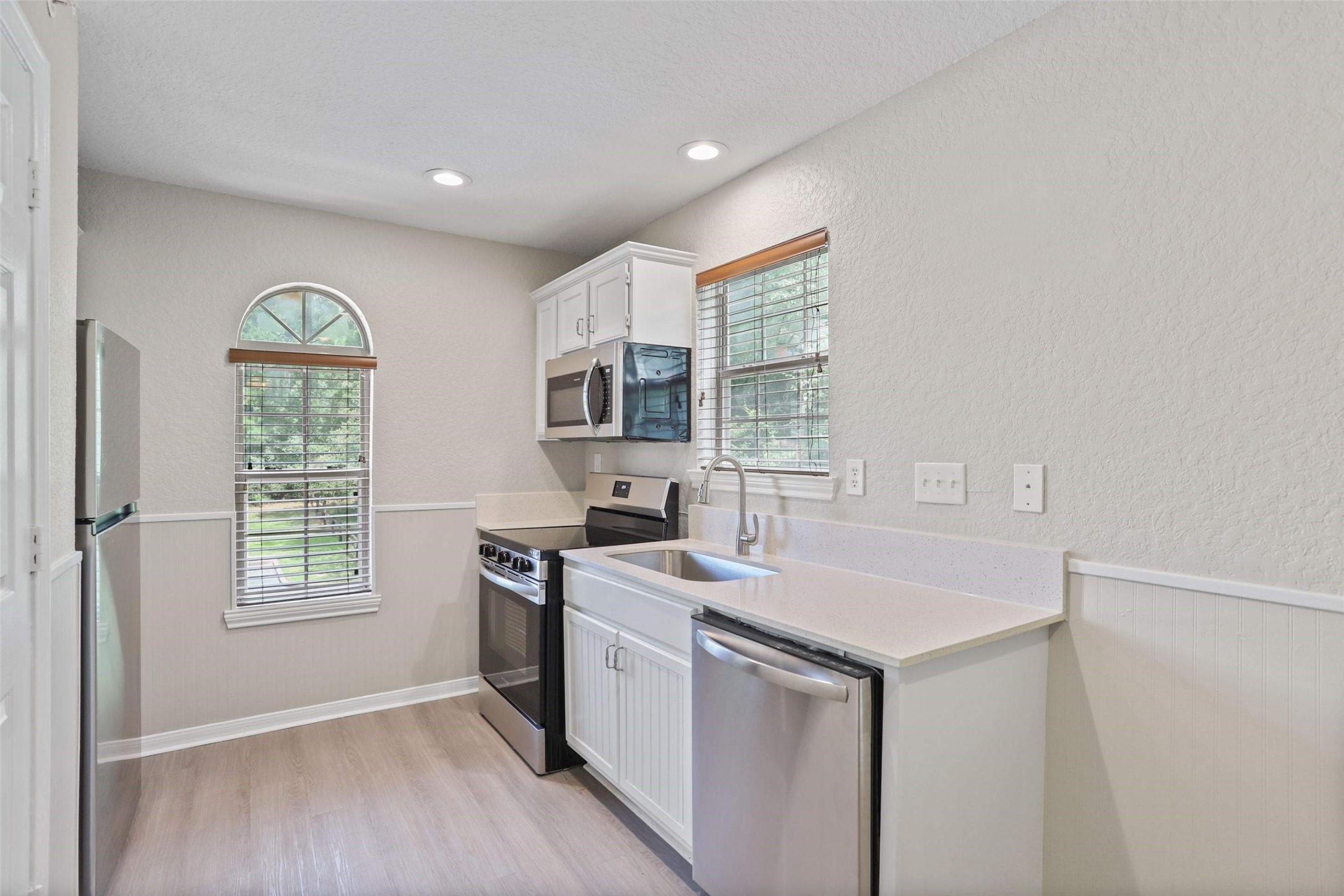 11700 League Line Road, Unit 122 Conroe, TX 77304 - Photo 4 of 25 a kitchen with a stove a sink and a window