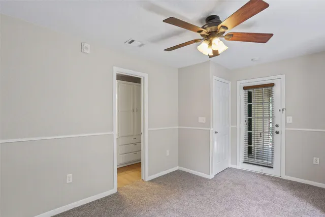 an empty room with closet and a chandelier fan