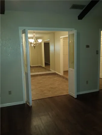 a view of an empty room with wooden floor and a fireplace