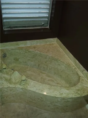 a white toilet sitting next to a bathroom sink and a mirror