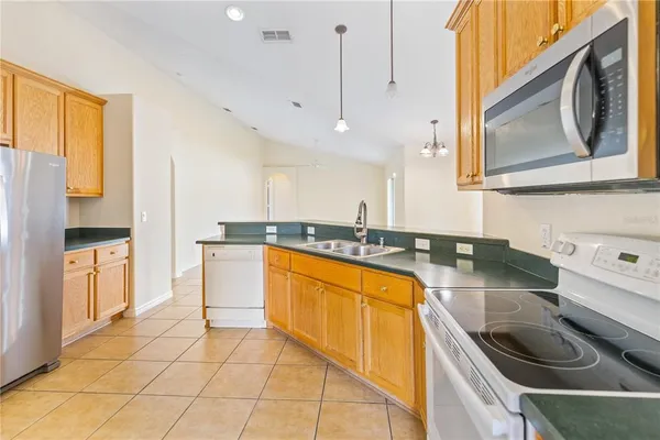 a kitchen with a sink a counter top space appliances and cabinets