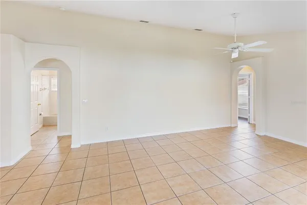 an empty room with wooden floor and fan