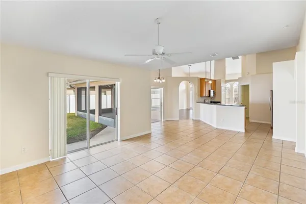 an empty room with wooden floor ceiling fan and windows