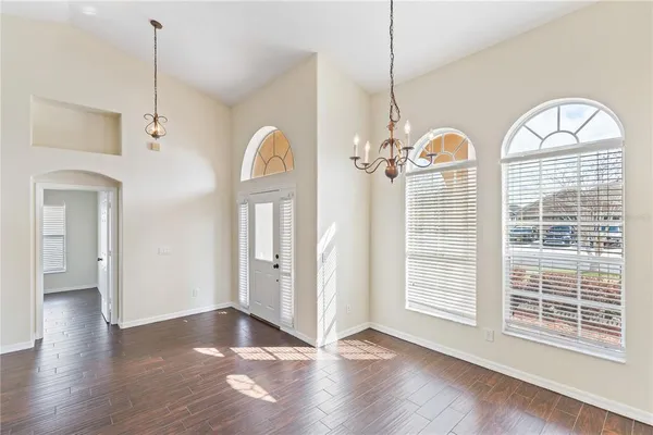 a view of a room with wooden floor fireplace and windows