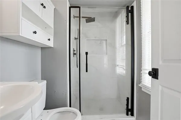a bathroom with a toilet and a shower