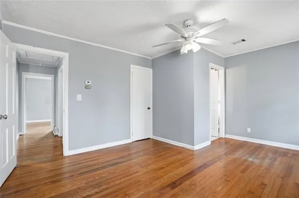 a view of a livingroom with a ceiling fan & hardwood floor