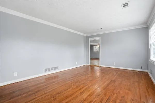 a view of an empty room with wooden floor