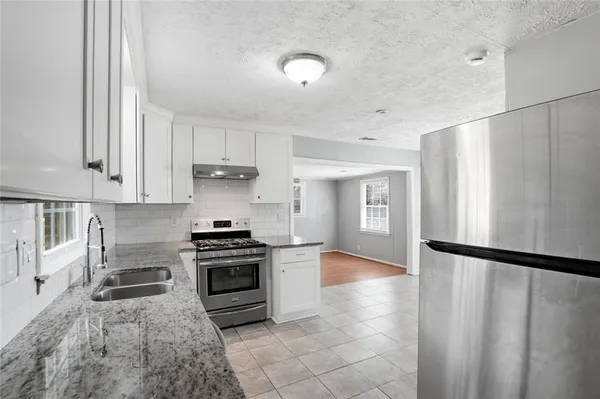 a kitchen with granite countertop a stove and a refrigerator