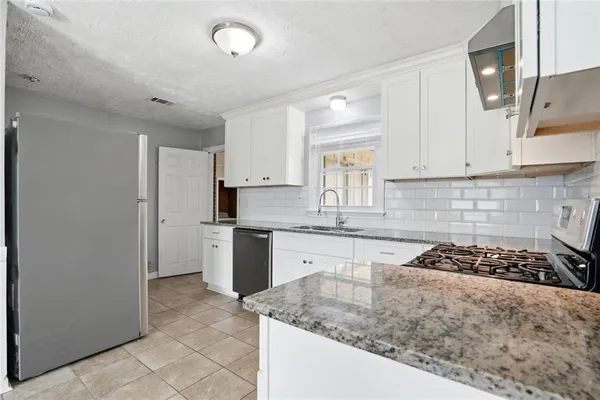 a kitchen with a sink stove top oven and cabinets