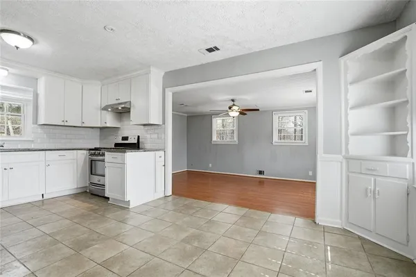 a kitchen with white cabinets and appliances