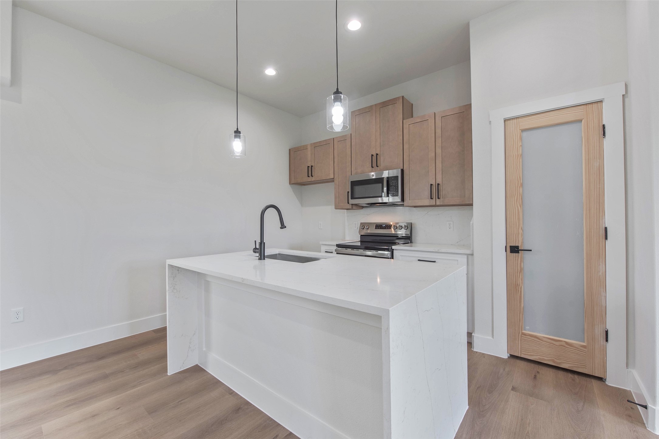 9311 Jutland Road Houston, TX 77033 - Photo 6 of 28 The kitchen features a large island with a farmhouse sink, beautiful cabinetry, a spacious pantry, and sleek stainless steel appliances.