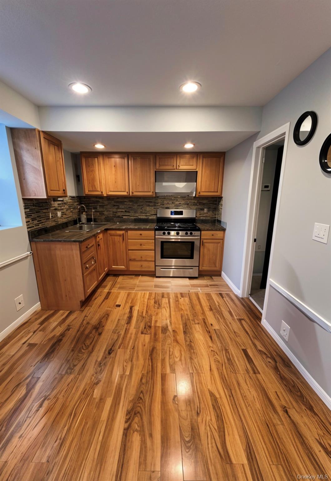 227 Calhoun Avenue Bronx, NY 10465 - Photo 2 of 17 a kitchen with stainless steel appliances wooden floor and a refrigerator
