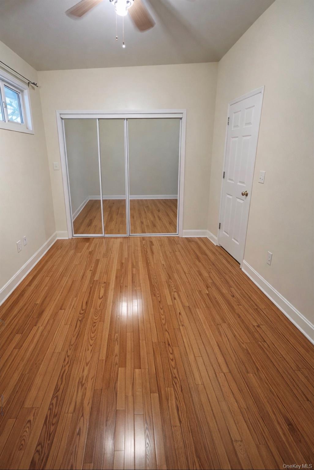 227 Calhoun Avenue Bronx, NY 10465 - Photo 10 of 17 an empty room with wooden floor and windows