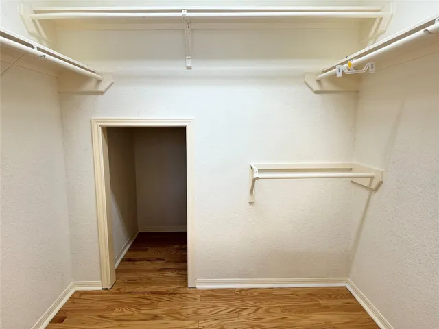a view of walk in closet with empty racks