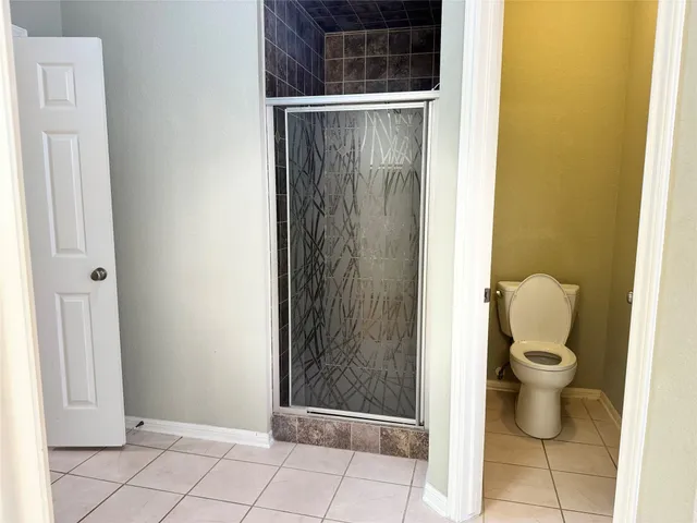 a bathroom with a toilet and a shower