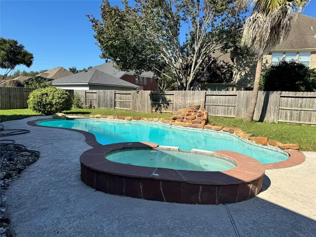 a view of a house with backyard sitting area and swimming pool