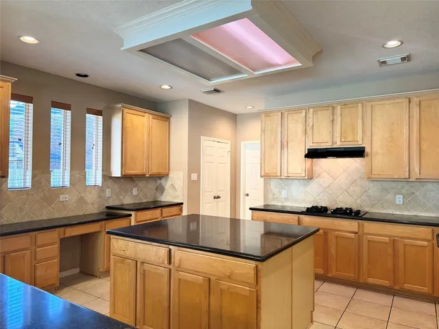 a kitchen with granite countertop a sink window and cabinets