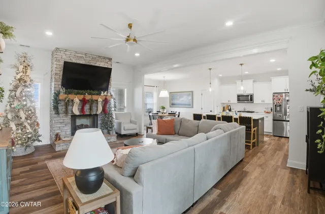 a living room with furniture kitchen view and a flat screen tv