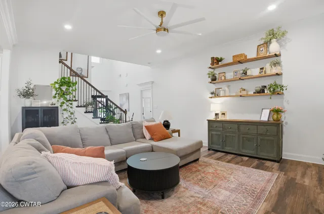 a living room with furniture and wooden floor