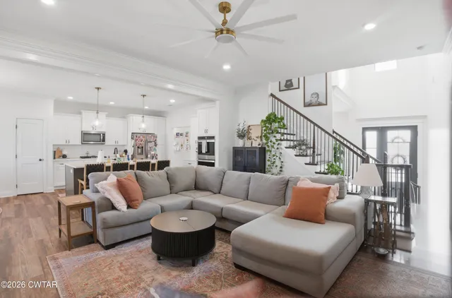 a living room with furniture and a view of kitchen