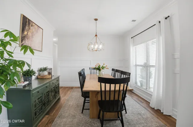 a dining room with furniture potted plants and wooden floor