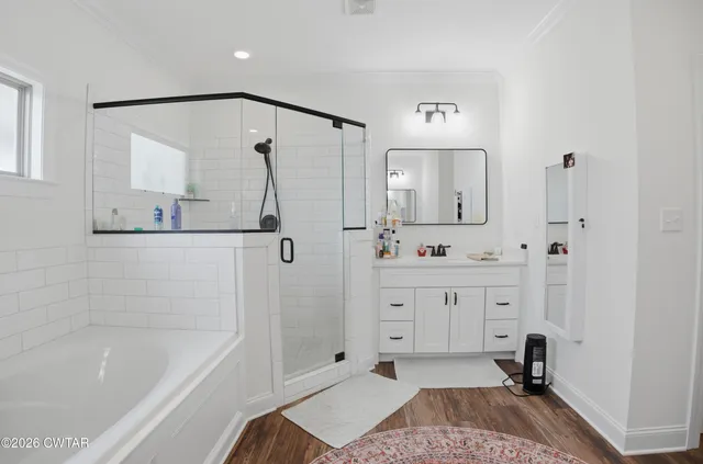 a spacious bathroom with a tub sink and a mirror